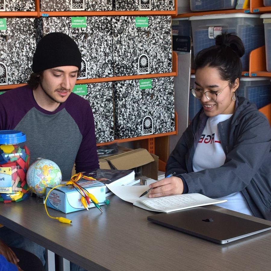 Two students work on lesson plans.