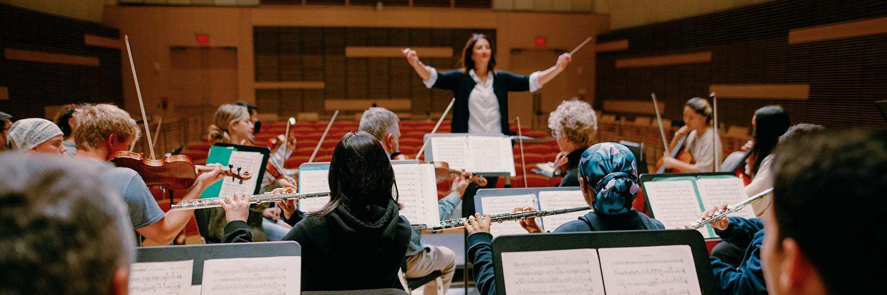 Students rehearse in the orchestra in university hall.